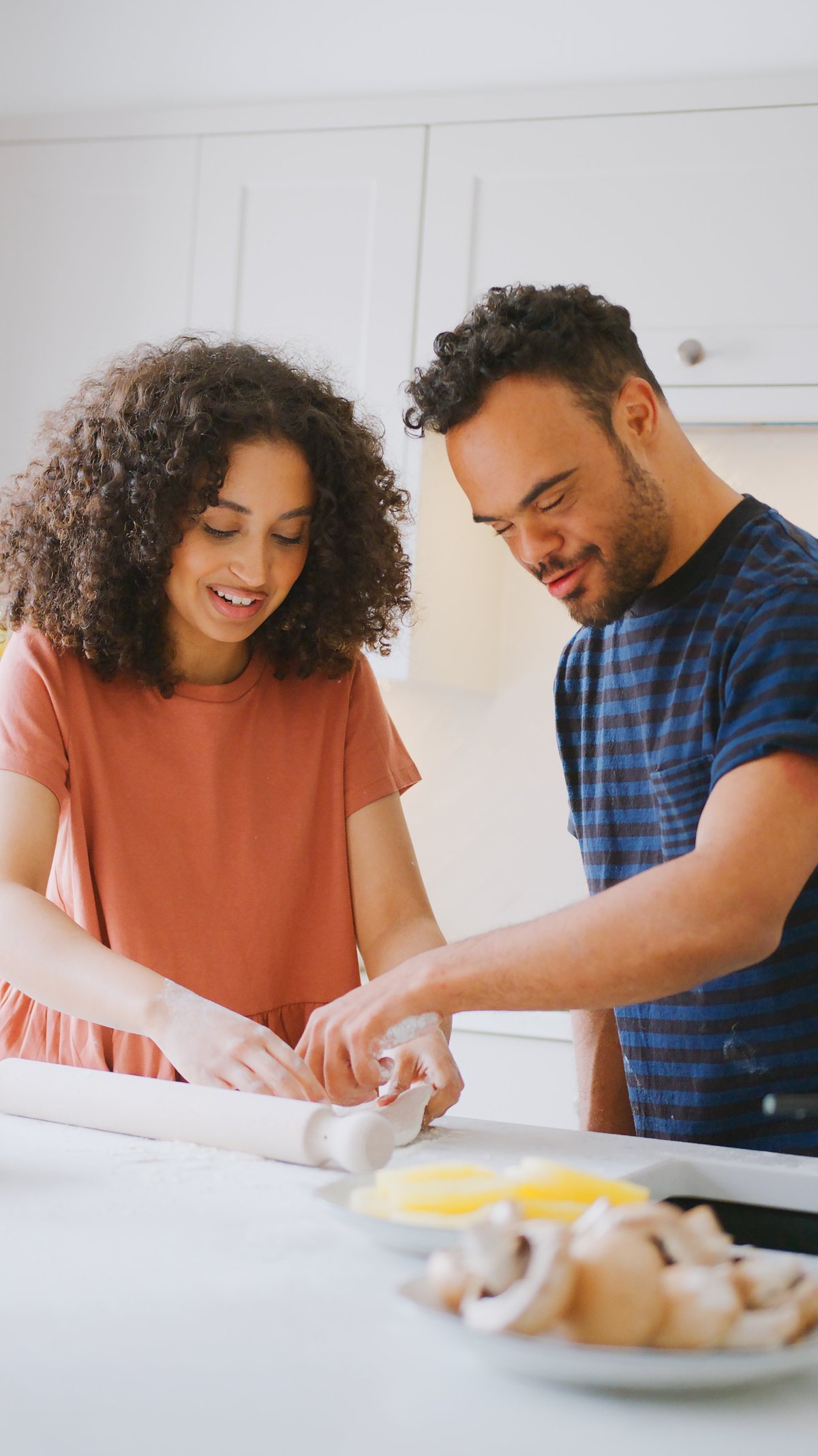 A couple with a man with Down syndrome making pizza together at home